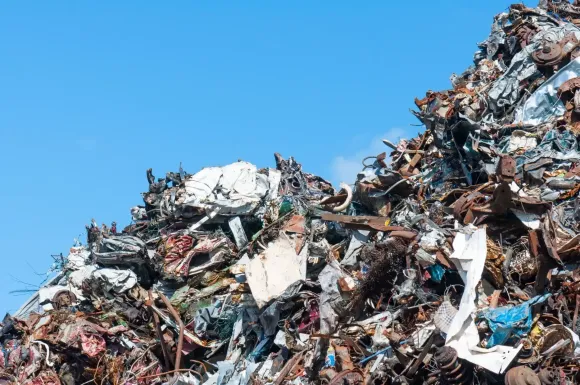Pila de chatarra contra un cielo azul brillante.