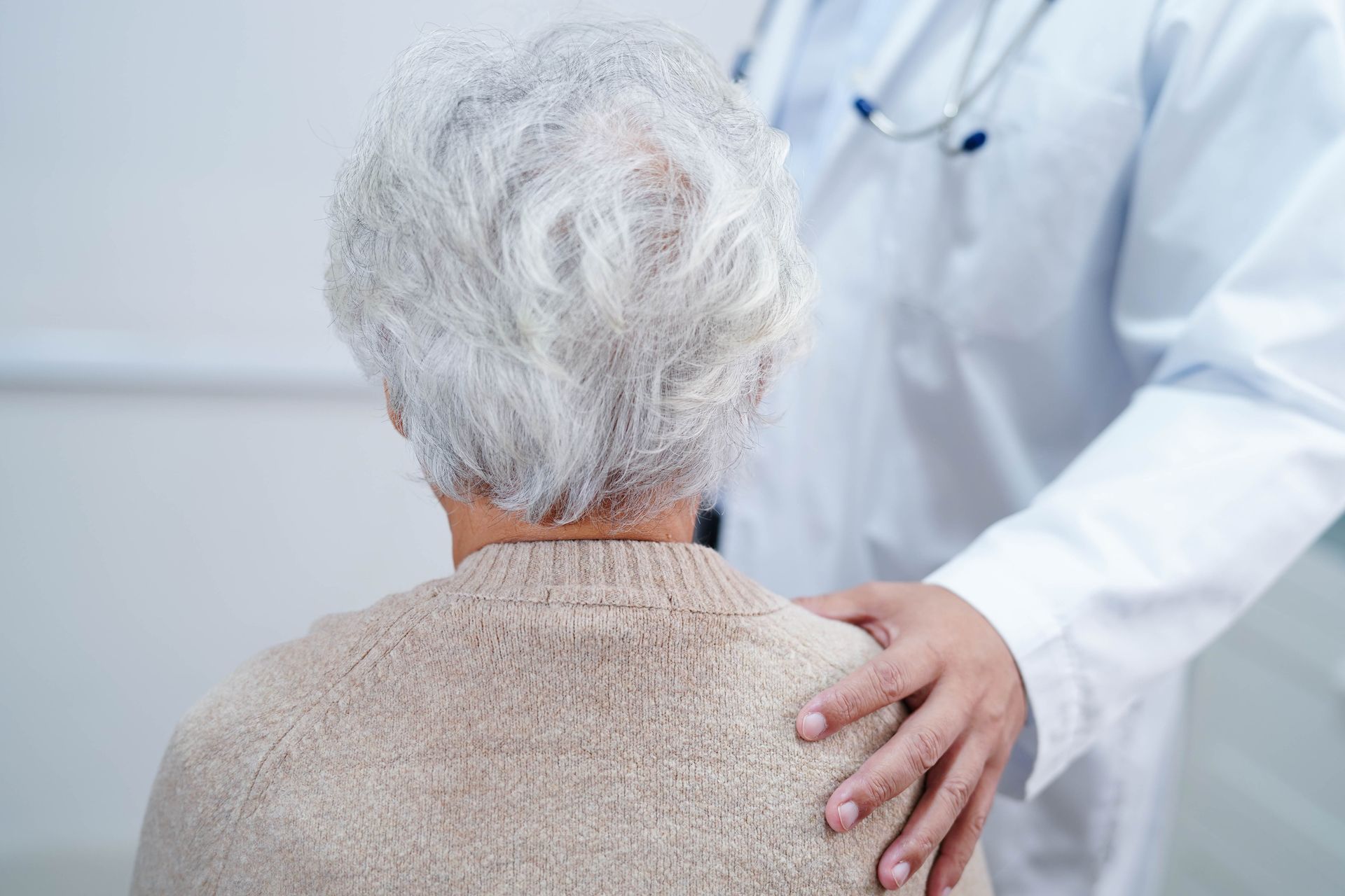 Une personne de dos avec une autre qui pose la main sur son épaule