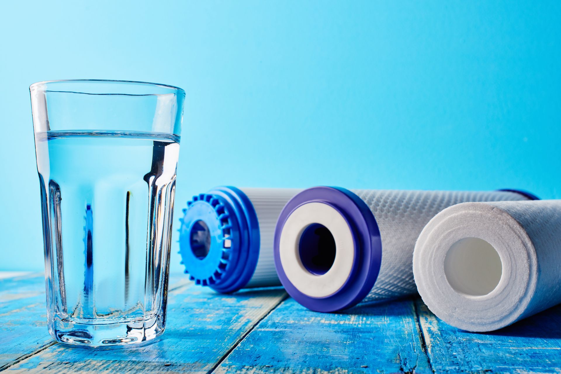 Trois filtres posés à côté d'un verre d'eau