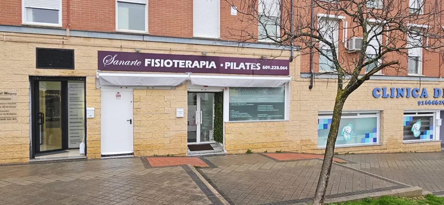 Vista de la calle de un local comercial con un letrero morado que dice 