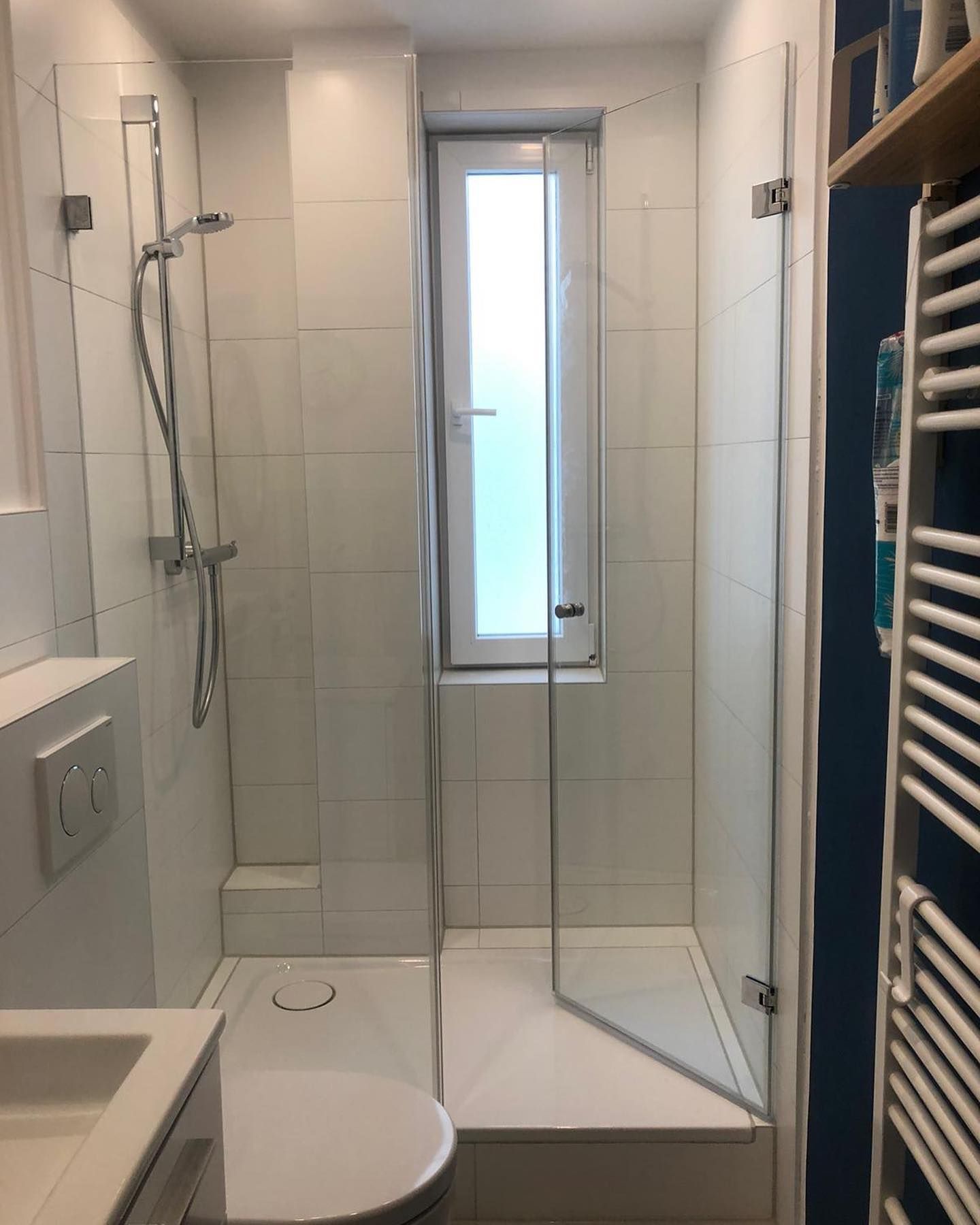 Ein Badezimmer mit Toilette, Waschbecken, Dusche und Fenster.