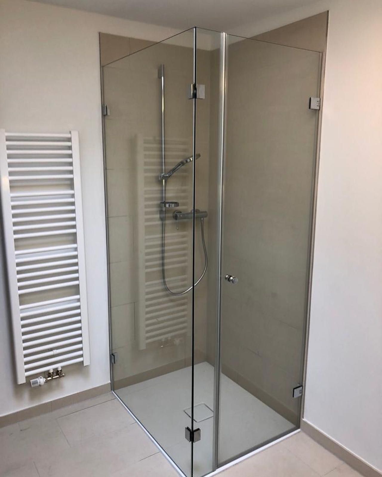 Ein Badezimmer mit Duschkabine und Handtuchhalter