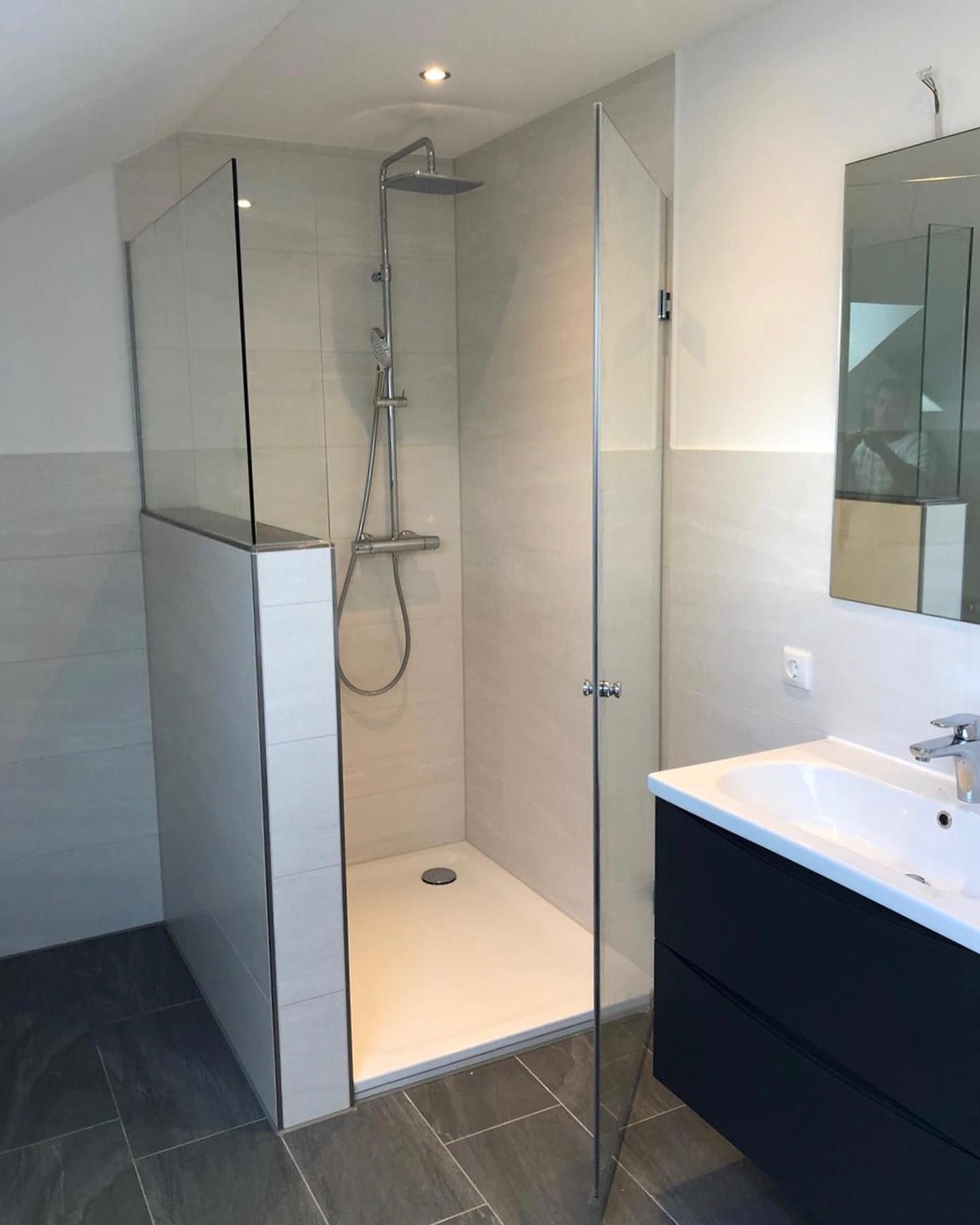 Ein Badezimmer mit ebenerdiger Dusche und Waschbecken