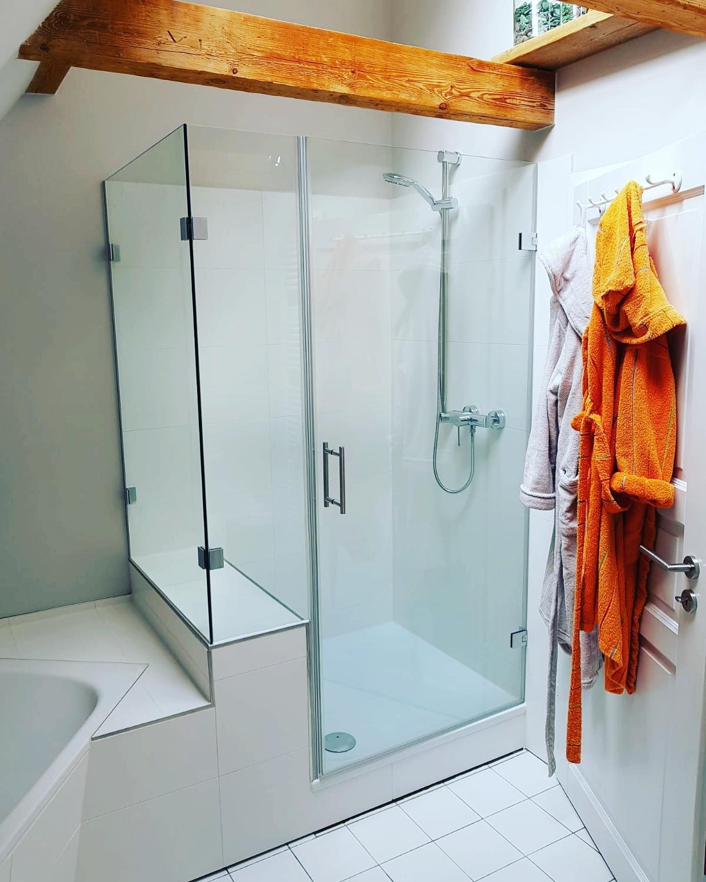 Ein Badezimmer mit ebenerdiger Dusche und Badewanne