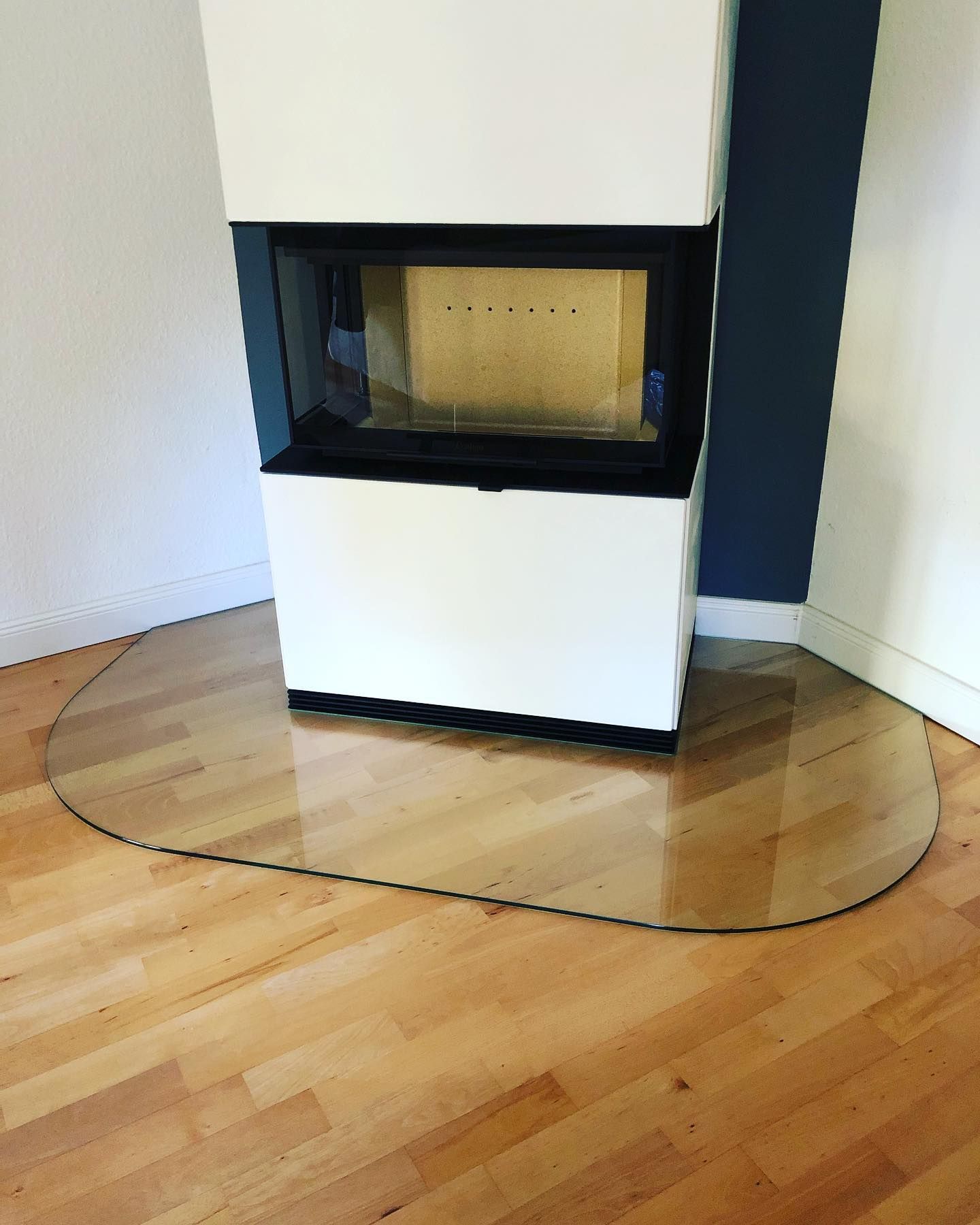 Ein Kamin mit einer Glasmatte auf dem Boden