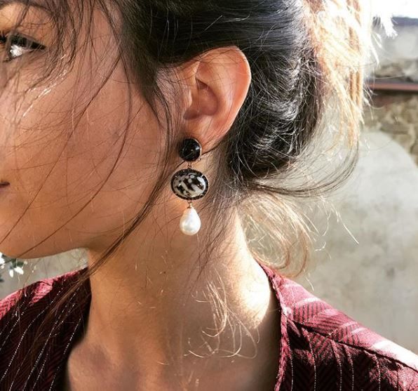 Un primer plano de una mujer que lleva un par de pendientes.