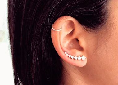 Un primer plano de la oreja de una mujer con pendientes.