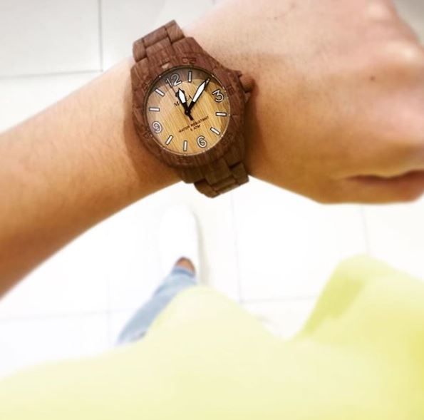 Una persona que lleva un reloj de madera en su muñeca