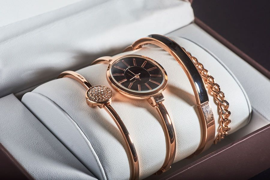 Un reloj y tres pulseras están en una caja.