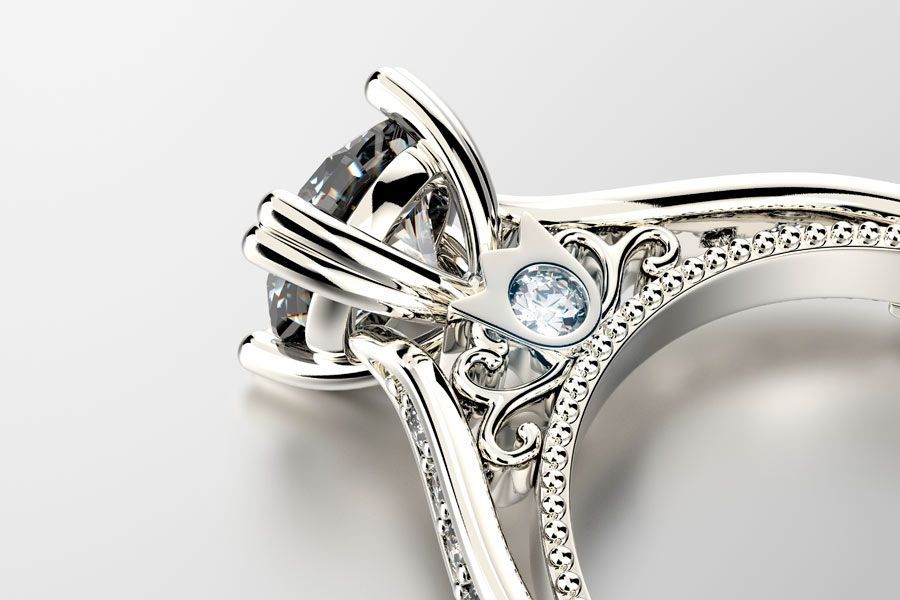 Un primer plano de un anillo de diamantes sobre una superficie blanca.