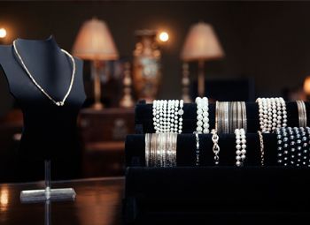 Un collar y pulseras están en exhibición en una tienda.