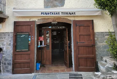Entrada de taberna con puerta de madera y puertas abiertas. Toldo color crema y fachada de piedra.