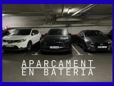 Coches aparcados en un garaje interior. Texto superpuesto: