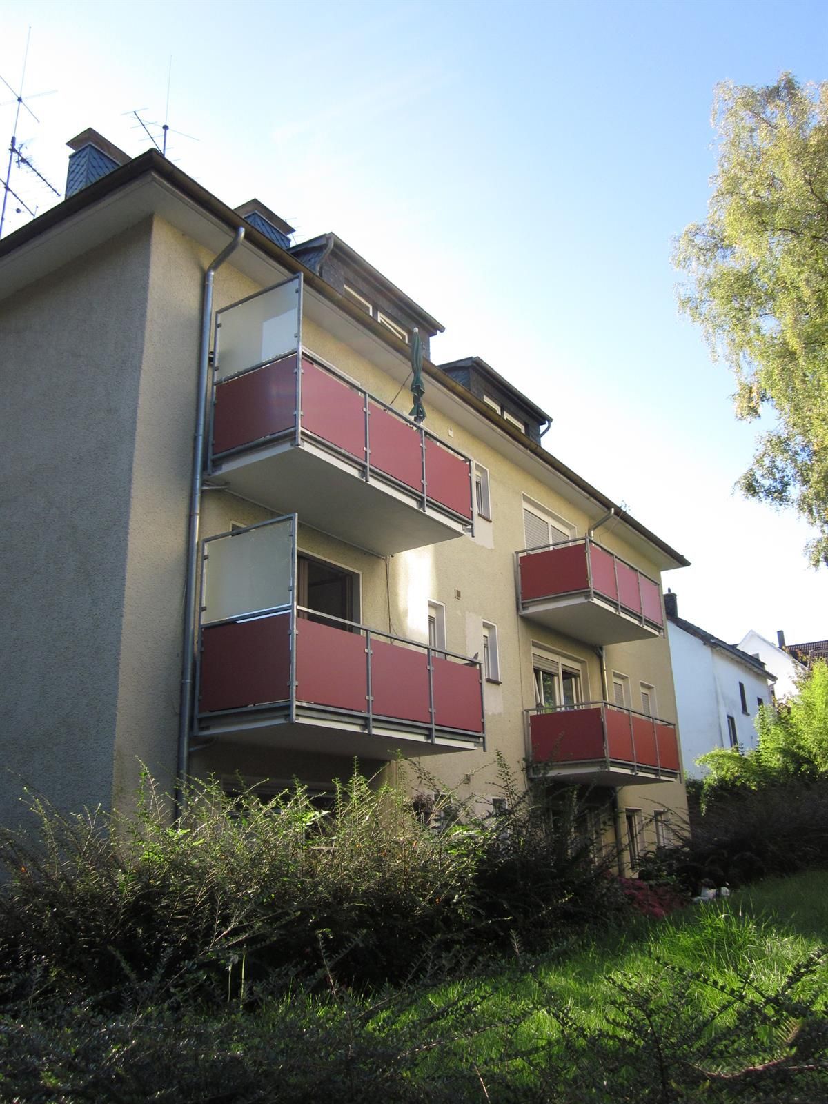 Ein Gebäude mit roten Balkonen und einem blauen Himmel im Hintergrund