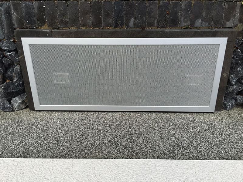 Neben einer Steinmauer liegt auf dem Boden ein Fliegengitter.