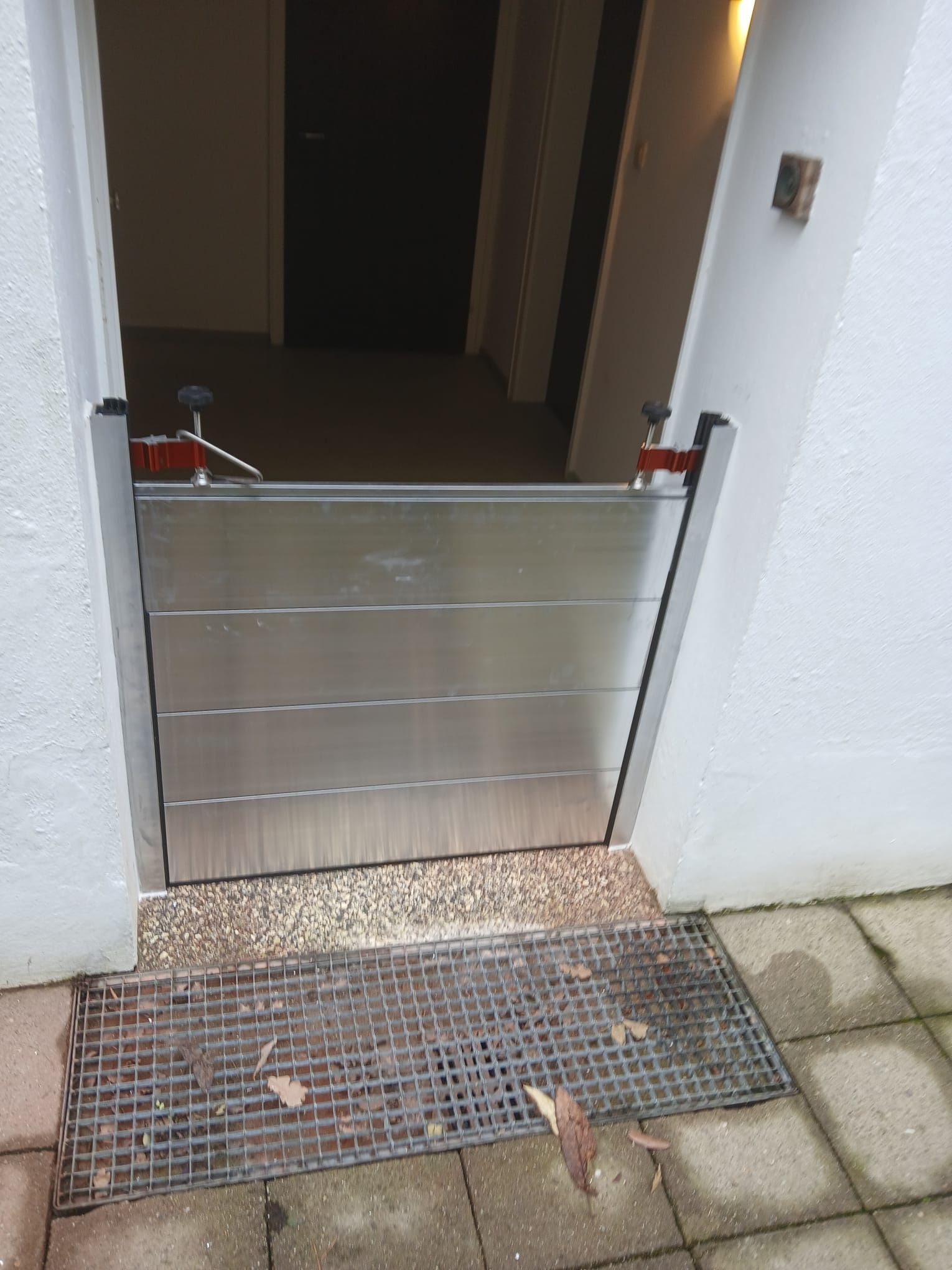 Eine Tür mit einer Metallbarriere als Hochwasserschutz davor