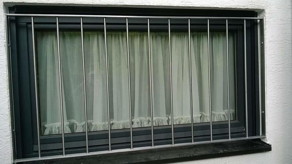 Ein Fenster mit einem Edelstahlzaun darum