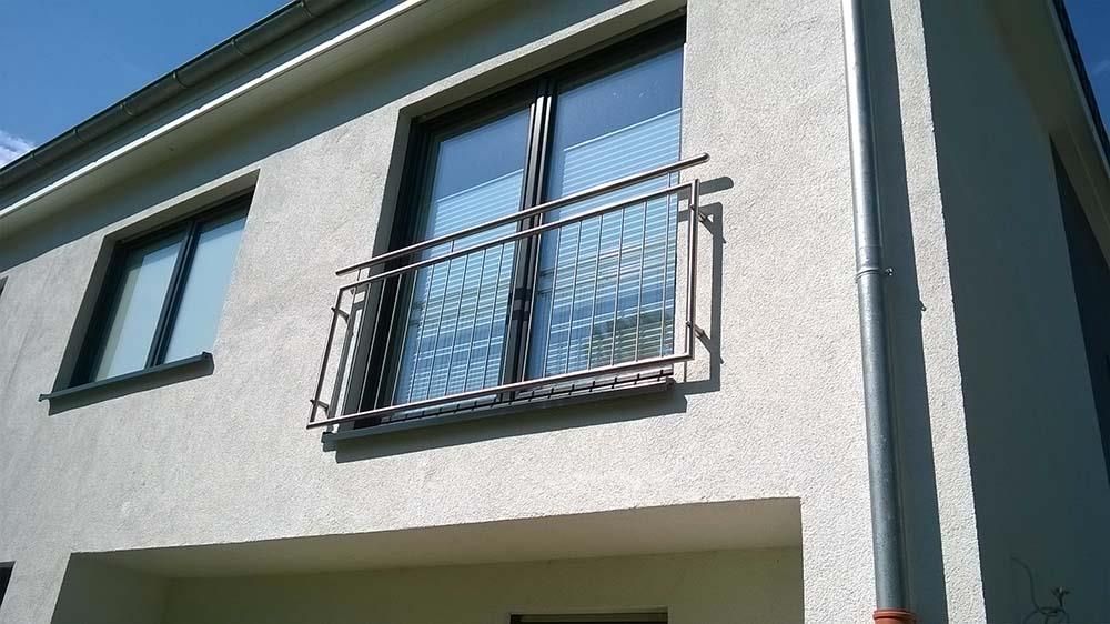 Ein weißes Haus mit schwarzen Fenstern und einem Balkon