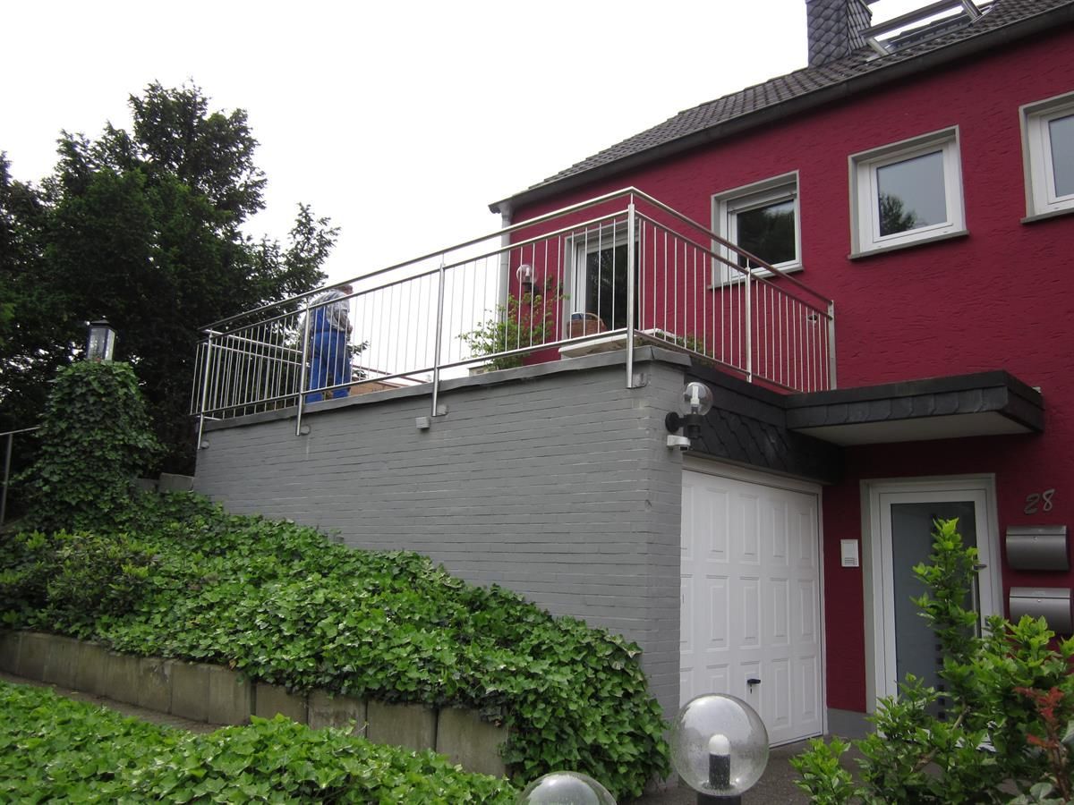 Ein rotes Haus mit einem Balkon an der Seite