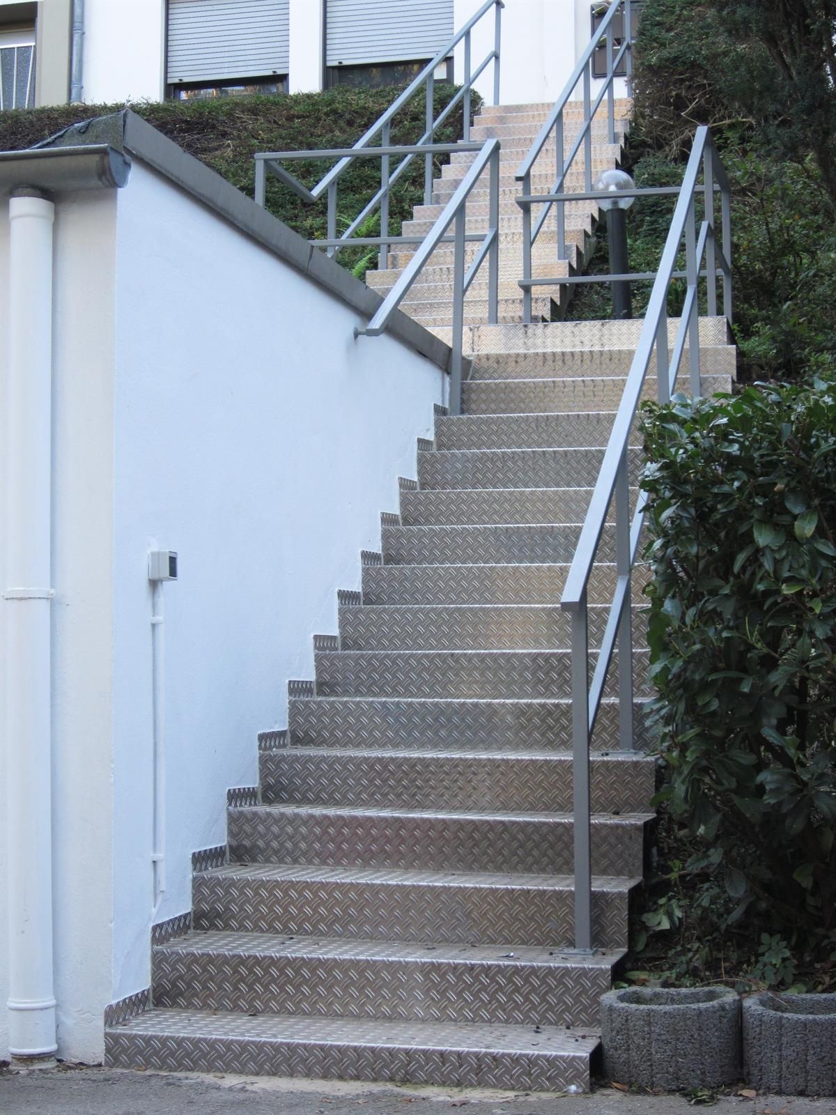 Eine Treppe, die zu einem Gebäude mit einem Metallgeländer führt