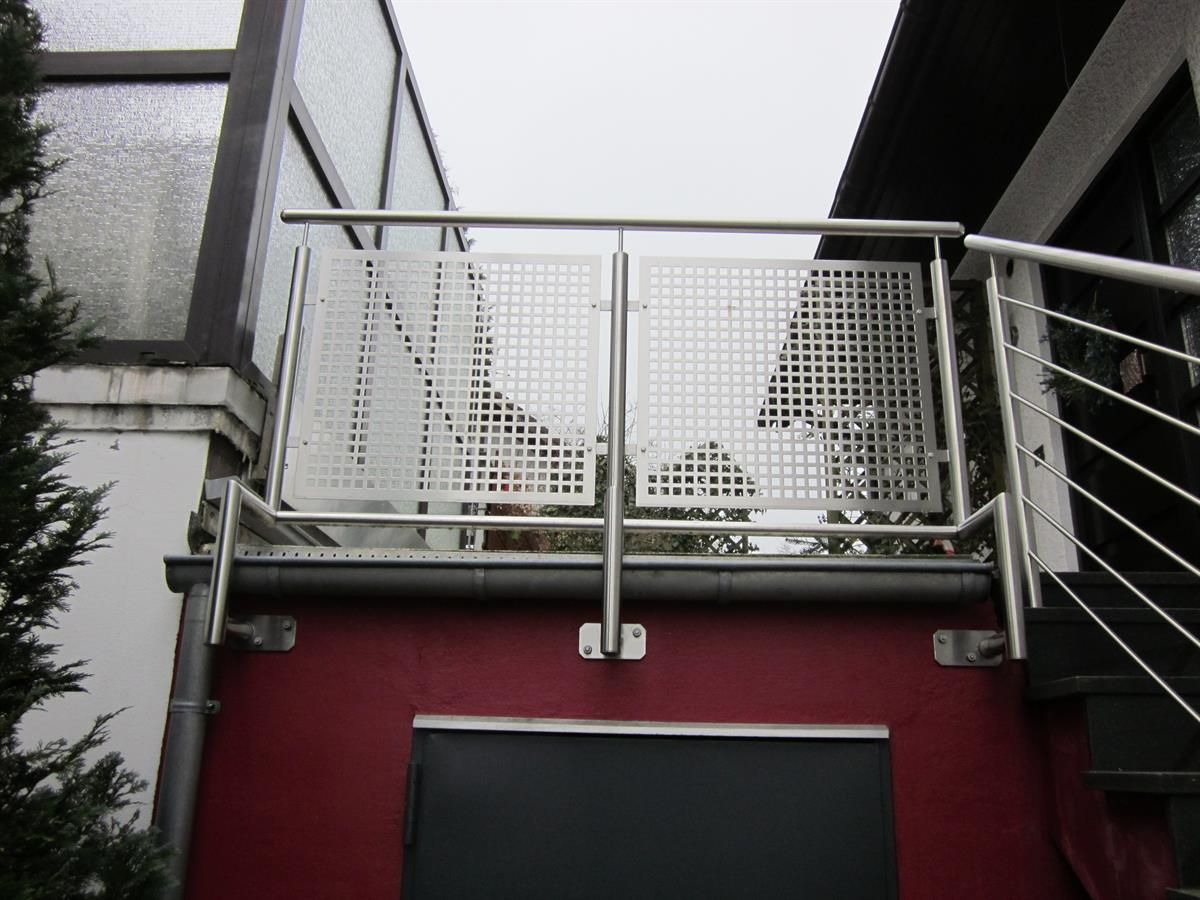 Ein Balkon mit einem Edelstahlgeländer an der Seite eines Gebäudes
