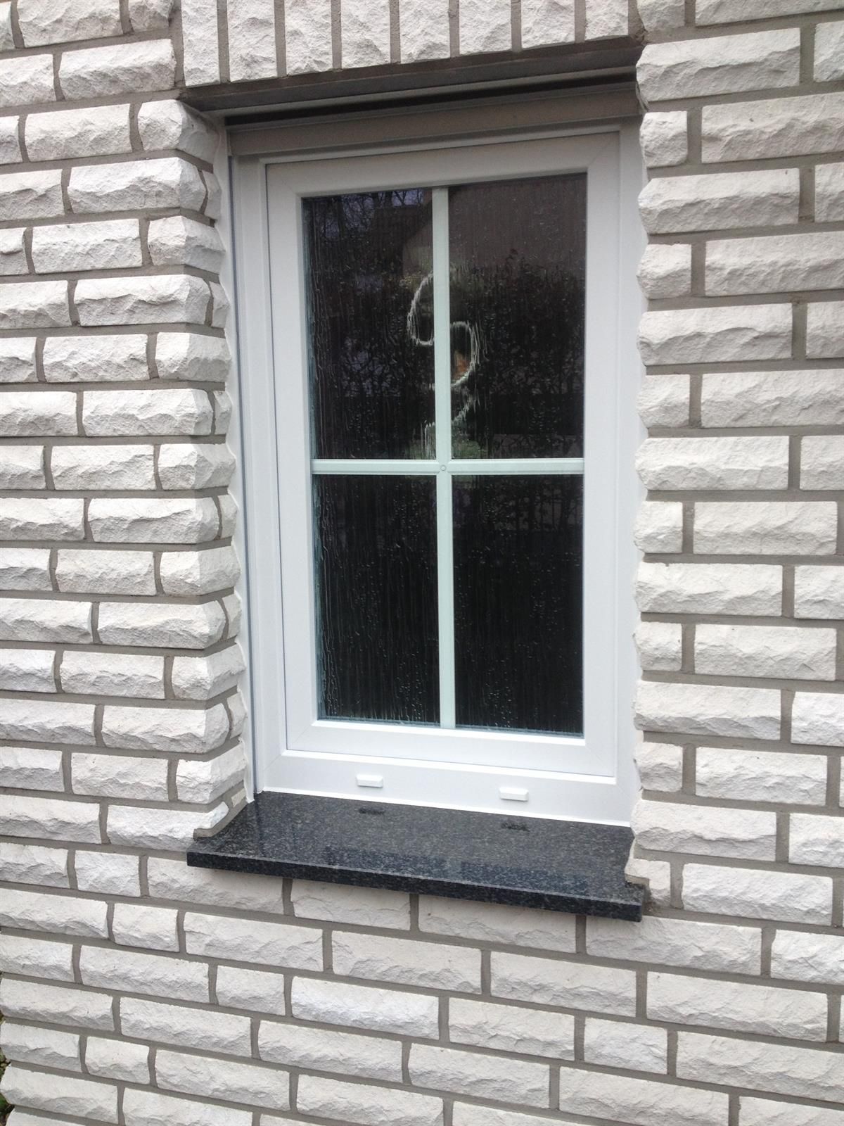 Ein weißes Fenster auf einer weißen Backsteinmauer