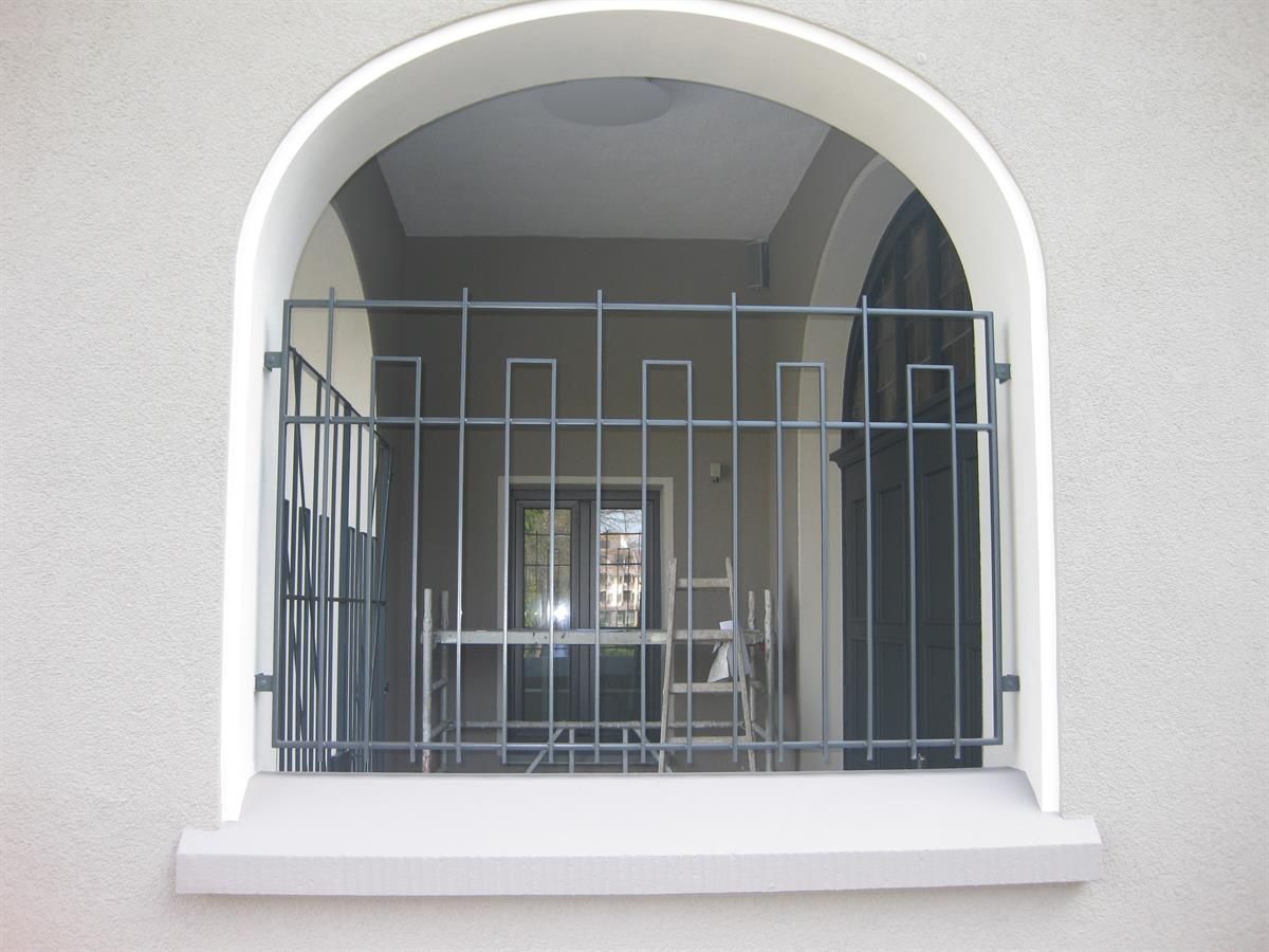 Ein Fenster mit einem Metallgeländer an der Seite