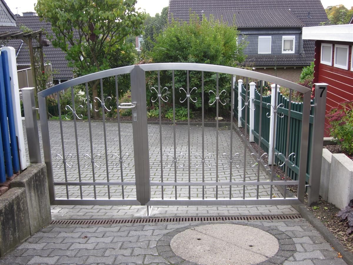 Ein Edelstahltor öffnet sich zu einer Einfahrt