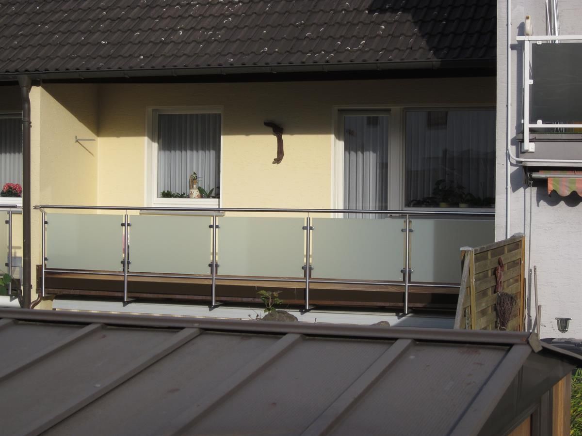 Ein Haus mit einem Balkon mit Edelstahlgeländer