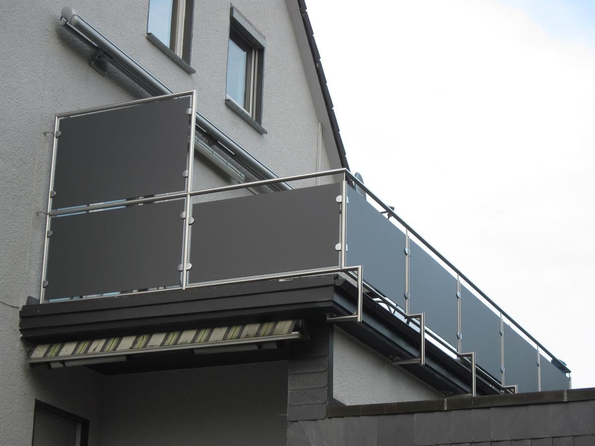 Ein Balkon an der Seite eines Gebäudes mit einem Edelstahlgeländer