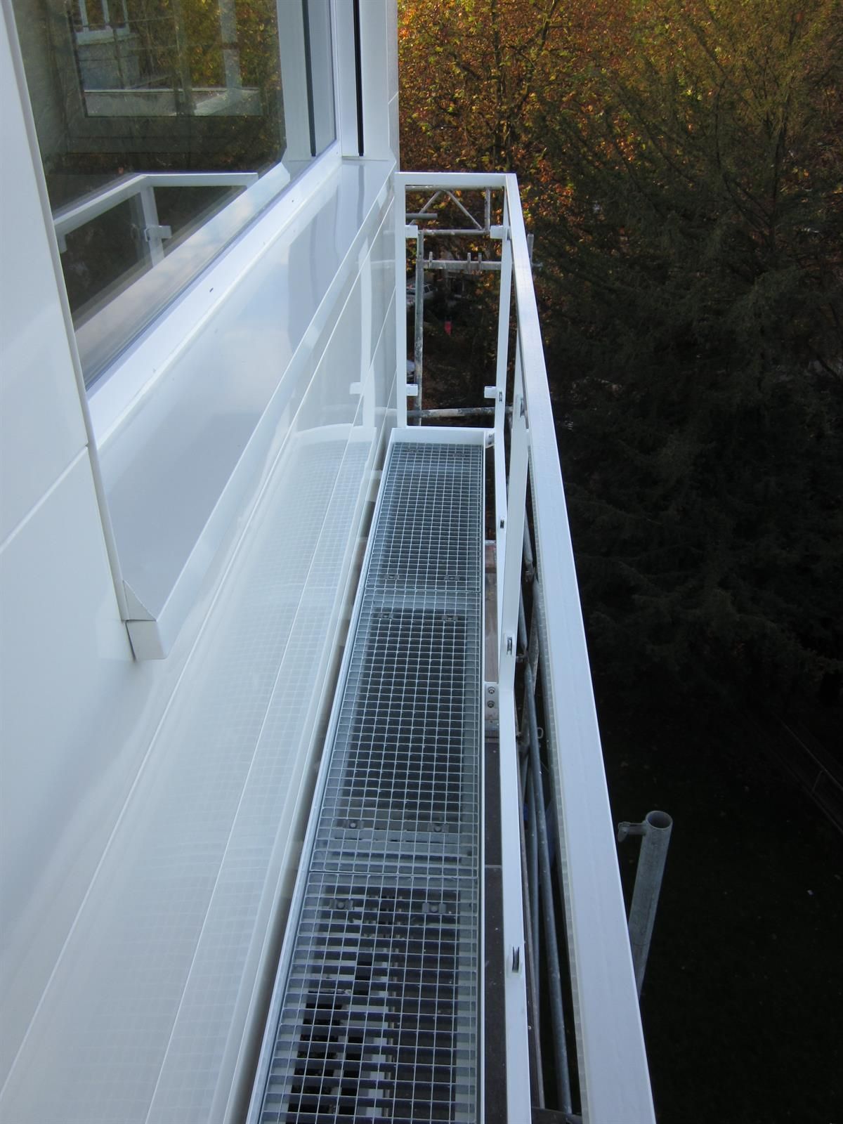 Ein weißer Balkon mit einer Metalltreppe, die dorthin führt