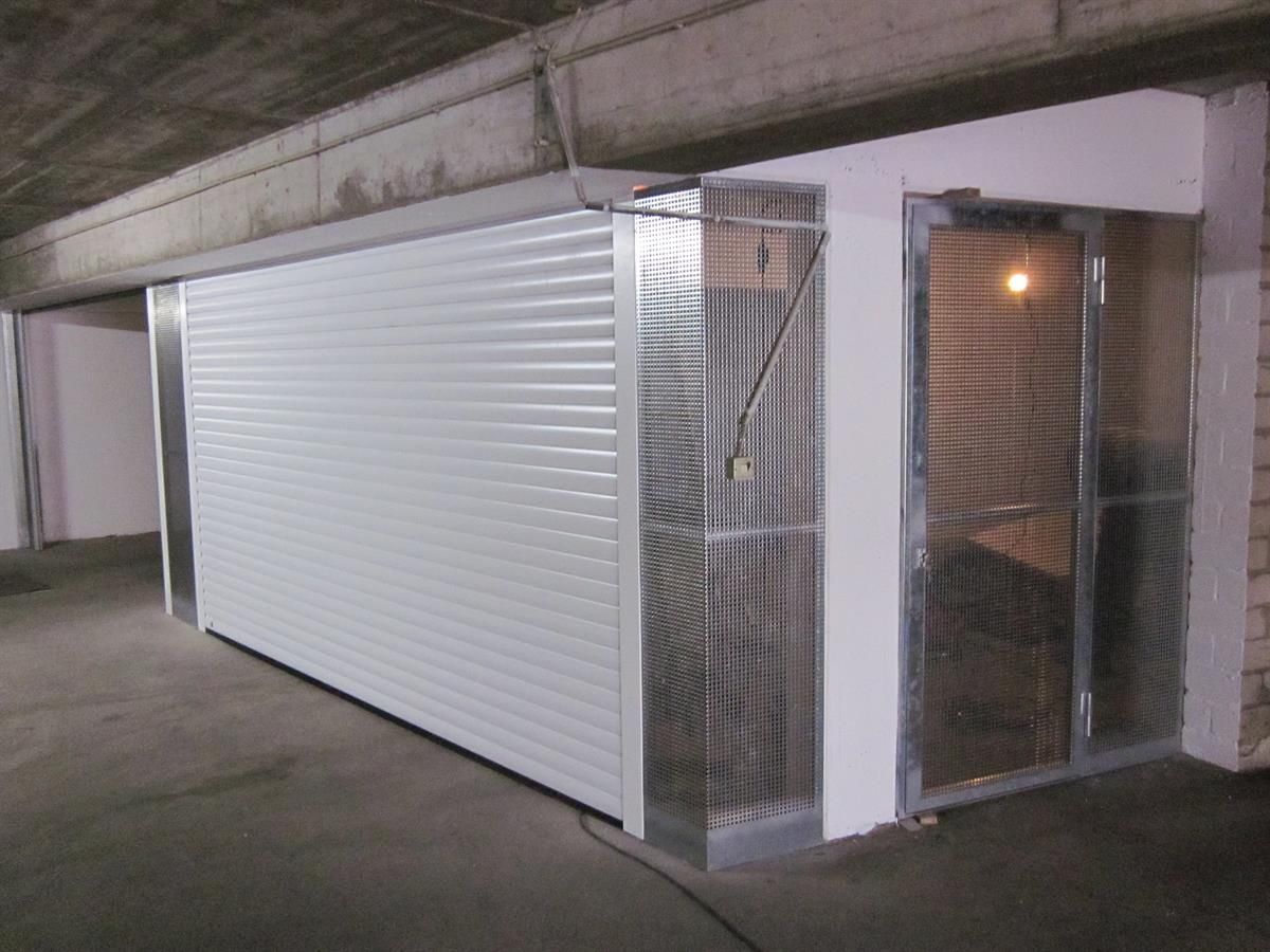 Eine Garage mit einem weißen Rolltor und einer Glastür