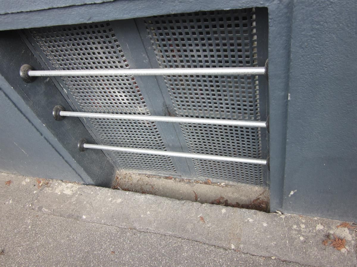Eine graue Wand mit einem Metallgitter darauf