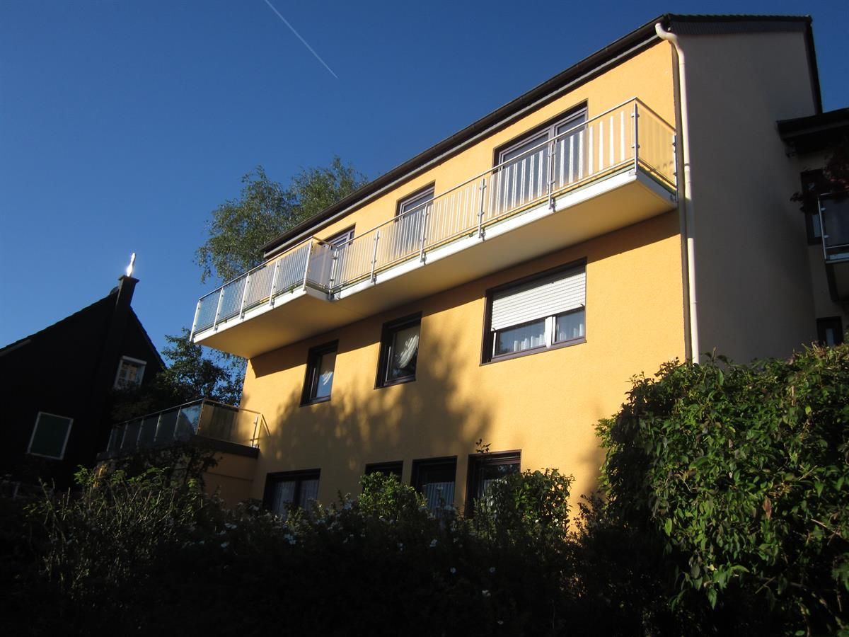 Ein gelbes Gebäude mit einem Balkon und einem blauen Himmel im Hintergrund