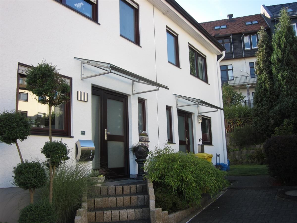 Ein weißes Haus mit einem Vordach über der Eingangstür