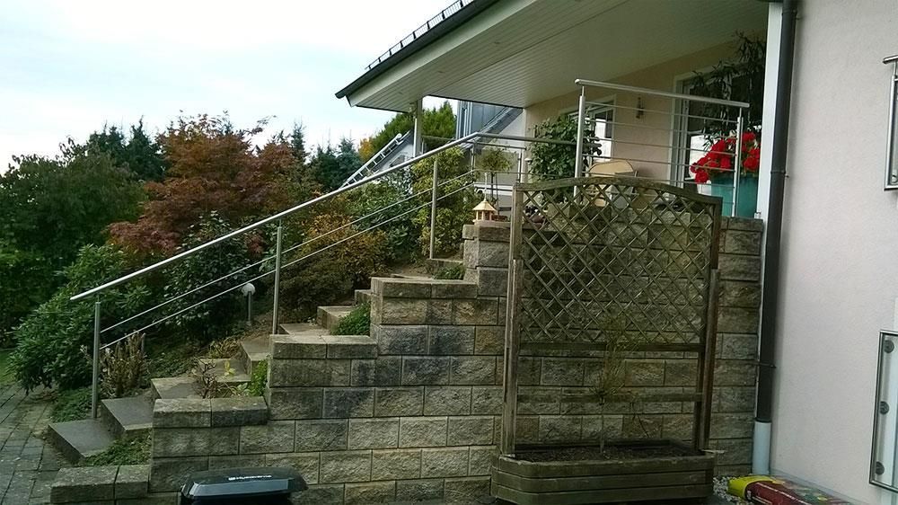 Eine Backsteinmauer mit Treppen, die zu einem Haus führen