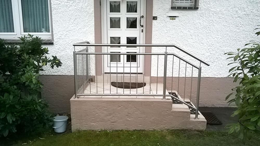 Ein weißes Haus mit einem Geländer und Treppen aus Edelstahl