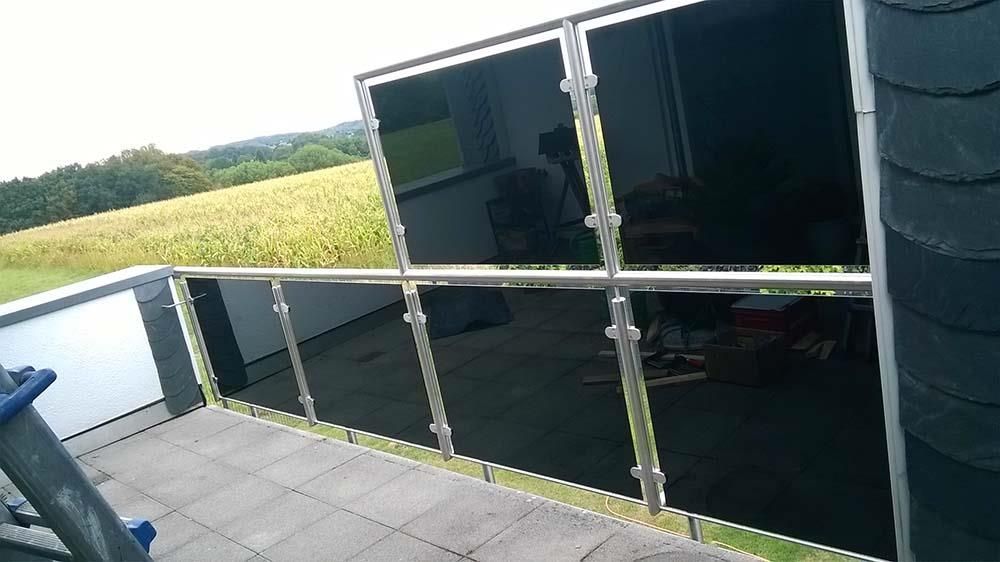 Ein Balkon mit Edelstahlgeländer und Blick auf ein Feld