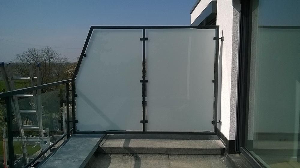 Ein Balkon mit Glasgeländer und Treppe, die dorthin führt