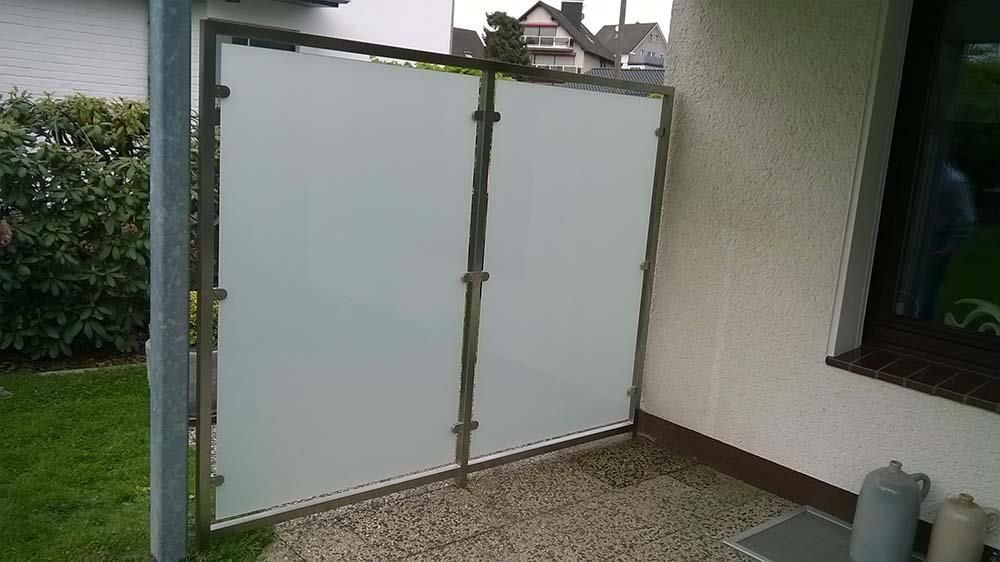 Vor einem Haus steht ein weißer Zaun.