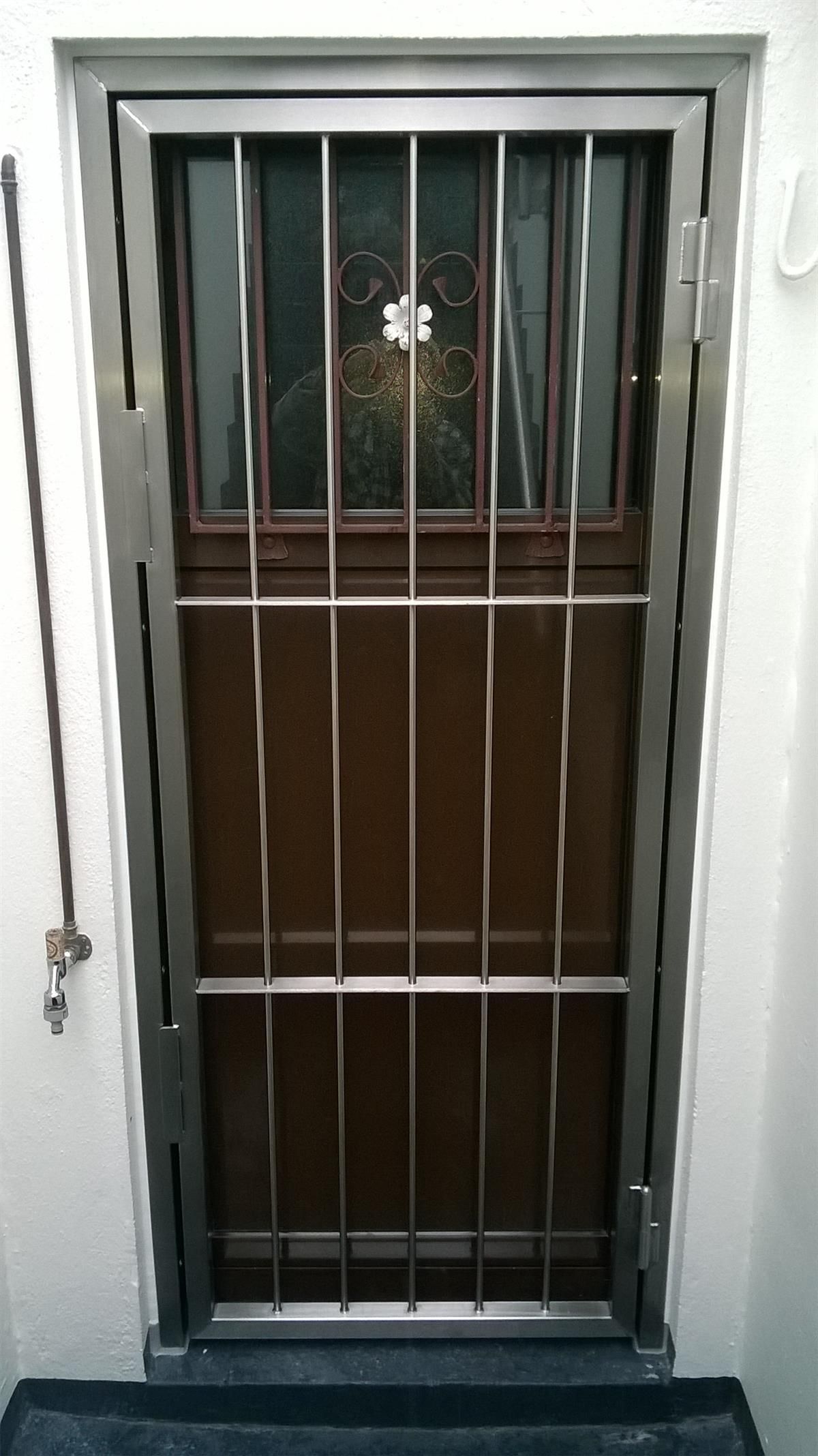Eine Tür mit einem Edelstahlgitter darauf.