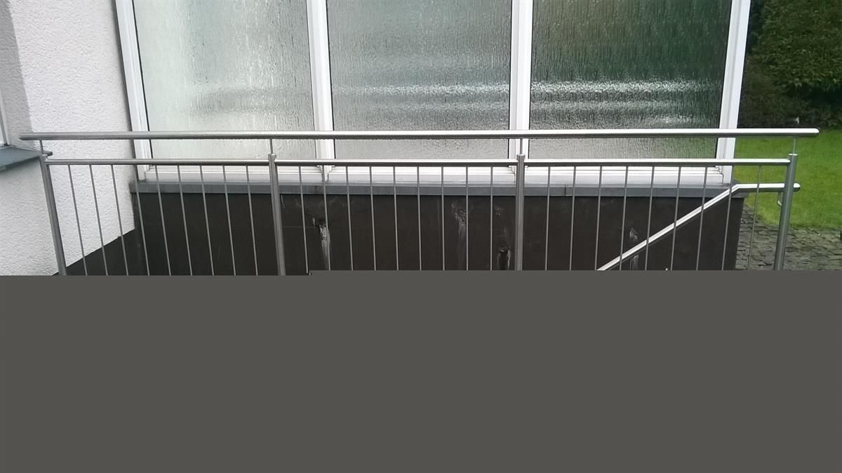 Ein Balkon mit Edelstahlgeländer und einer Treppe, die dorthin führt.