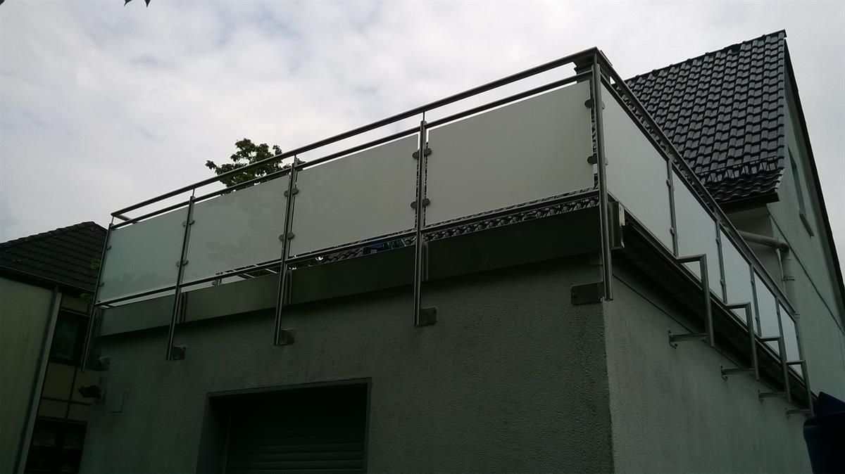 Ein Balkon an der Seite eines Gebäudes mit einem Edelstahlgeländer