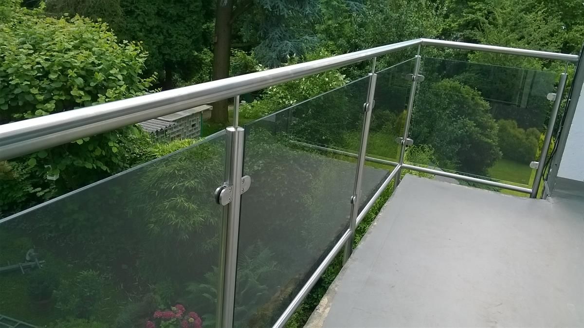 Ein Balkon mit Edelstahlgeländer und klarem Glas.