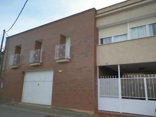 Un edificio de ladrillo con una puerta de garaje blanca y balcones.