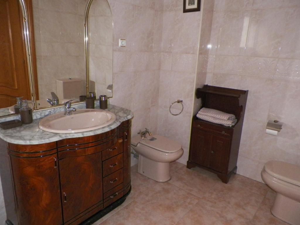 Un baño con lavabo, inodoro, bidé y espejo.