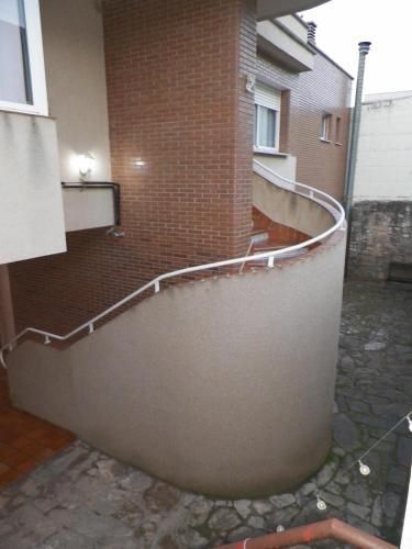 Una escalera curva que conduce a un edificio con una pared de ladrillo.