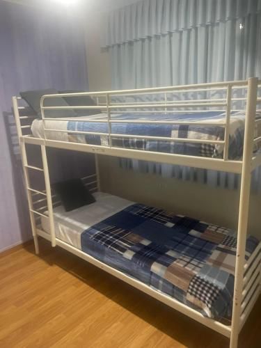 Una litera está ubicada en un dormitorio al lado de una ventana.