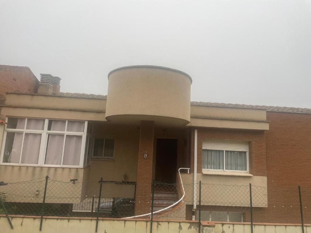 Una casa de ladrillo con un porche redondo y escaleras.