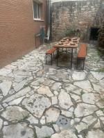 Un patio de piedra con una mesa y bancos frente a un edificio de ladrillo.